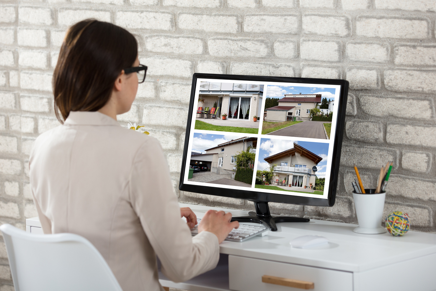 Woman Looking at House Listings on a Computer 